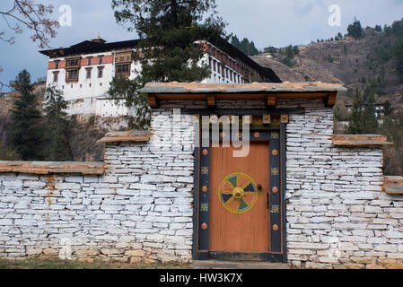 Bhutan, Paro, Rinpung Dzong. Detail of colorful orange painted Bhutanese door in front of 15th century Buddhist monastery and fortress. Tentative List Stock Photo