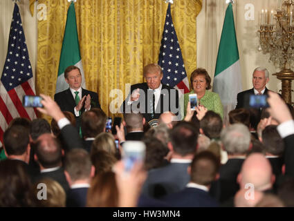 US President Donald Trump (centre) speaks as he stands with Irish Taoiseach Enda Kenny (left) and his wife Fionnuala Kenny and Mike Pence during the St. Patrick's Day Reception and Shamrock Presentation Ceremony, in the White House, Washington DC, USA. Stock Photo