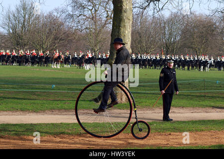 London, UK. 16th Mar, 2017. A man on a Penny Farthing bicycle rides along as members of HM Household Cavalry parade for the Major General's Review in Hyde Park, London. The Household Cavalry is made up of the two most senior regiments of the British Army, The Blues and Royals and the Life Guards. They will be seen at many Royal engagements this year. They were inspected by Major General Ben Bathurst, the General Officer Commanding the Army in London and the Queen's Household Troops, this morning, in Hyde Park, London on March 16, 2017. Credit: Paul Marriott/Alamy Live News Stock Photo