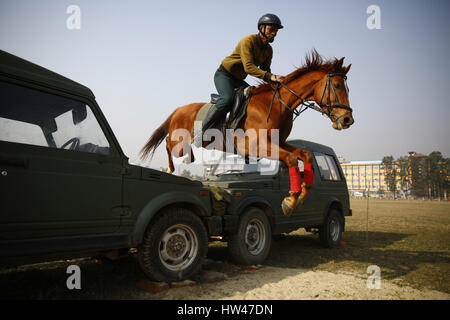 Kathmandu, Nepal. 17th Mar, 2017. A Nepalese Army soldier on a horse jumps over vehicles during the rehearsal for upcoming Ghode festival or Horse Parade at Tundikhel in Kathmandu, Nepal. According to myths it is believed that Ghode Jatra is celebrated as triumph over the demon that once was a horror in the city and by galloping horses the demon spirit stays under the ground. Credit: Skanda Gautam/ZUMA Wire/Alamy Live News Stock Photo