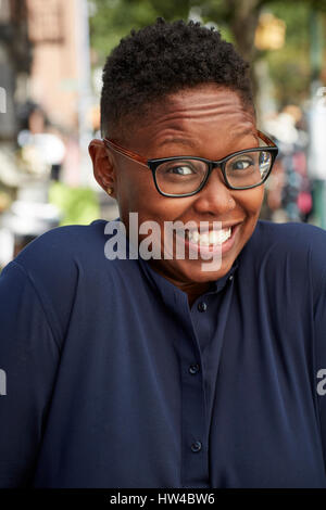 Portrait of Black woman shrugging on city sidewalk Stock Photo