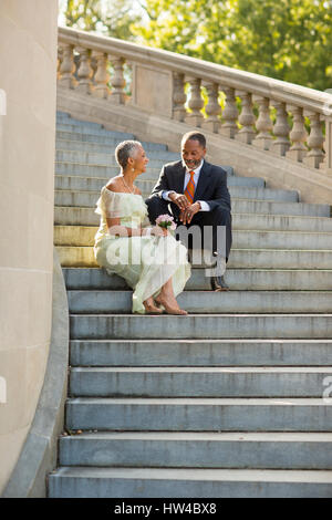 Black couple sitting on stone staircase Stock Photo