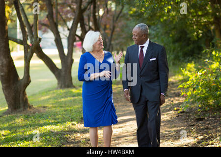 Couple walking and talking on path in park Stock Photo