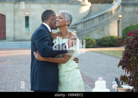 Black couple hugging near wedding cake Stock Photo