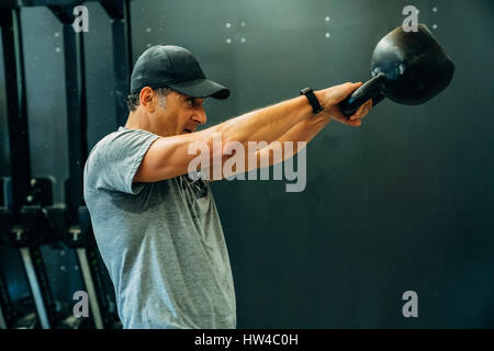 Portrait of Caucasian man lifting kettlebell Stock Photo