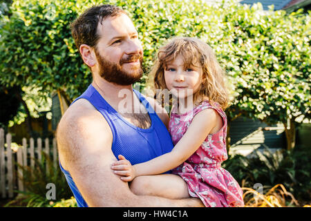 Portrait of Caucasian father carrying daughter Stock Photo