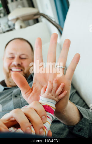 Father high-fiving baby daughter Stock Photo