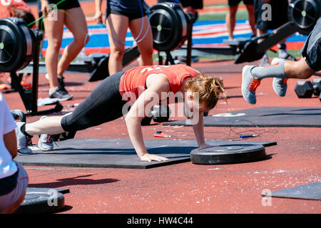 Woman doing push-ups outdoors Stock Photo