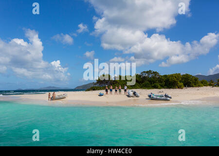 Tourists standing on tropical beach Stock Photo