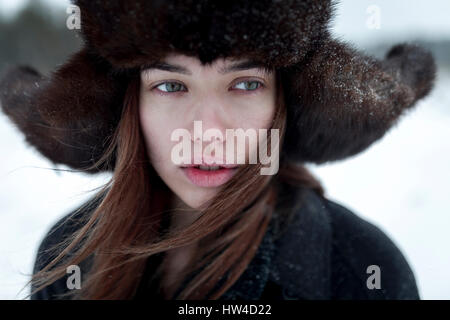 Serious Caucasian woman wearing fur hat and coat in winter Stock Photo