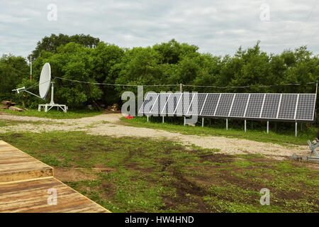 Solar panels and satellite dish on the source of river Ozernaya on Kurile lake. South Kamchatka Nature Park. Stock Photo