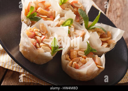 Homemade Mini Phyllo Cups with apples and peanuts closeup on a plate. Horizontal Stock Photo