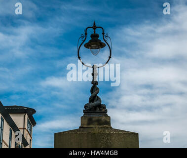 Old decorative street light with fantastical coiled fish sculpture, Leith, Edinburgh, Scotland, UK, against a blue sky with wispy clouds Stock Photo