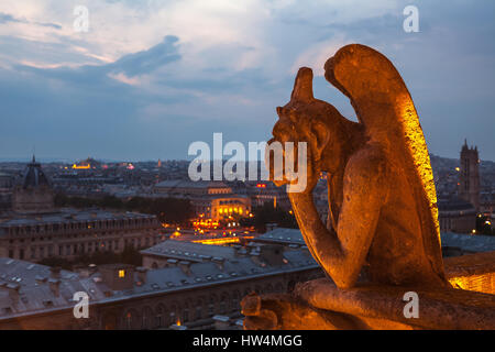 PARIS - JULY 15,2014: Gargoyle on the roof of Notre Dame, Paris Cathedral. Night view from the roof top of Notre Dame de Pari. July 15,Paris, France. Stock Photo