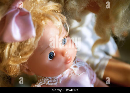 Cute plastic doll with bow. Close up. Stock Photo