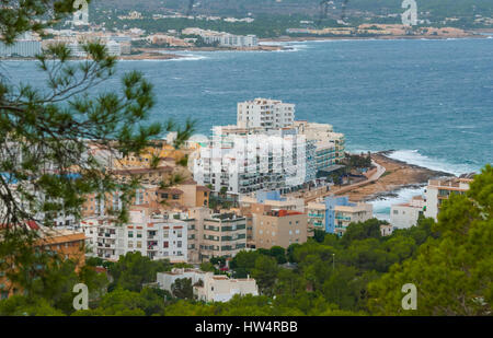 View from the hills in St Antoni de Portmany & surrounding area in Ibiza.  Hotels along the beach, places to stay.  Waves crash as surf onto shore. Stock Photo