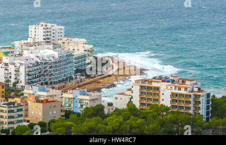 View from the hills in St Antoni de Portmany & surrounding area in Ibiza.  Hotels along the beach, places to stay.  Waves crash as surf onto shore. Stock Photo