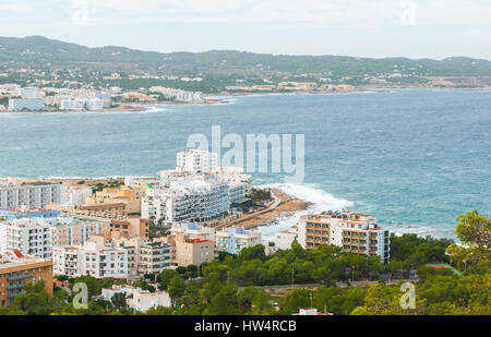 View from the hills in St Antoni de Portmany & surrounding area in Ibiza.  Hotels along the beach, places to stay.  Waves crash as surf onto shore. Stock Photo