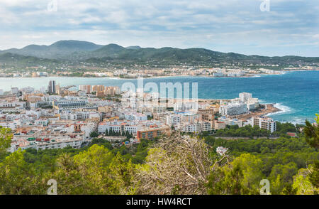 View from the hills in St Antoni de Portmany & surrounding area in Ibiza.  Hotels along the beach, places to stay.  Waves crash as surf onto shore. Stock Photo