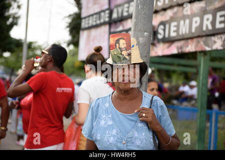 Cuban woman wearing a hat with Fidel Castro photograph attached during the May Day celebrations in Santiago De Cuba, Cuba. Stock Photo