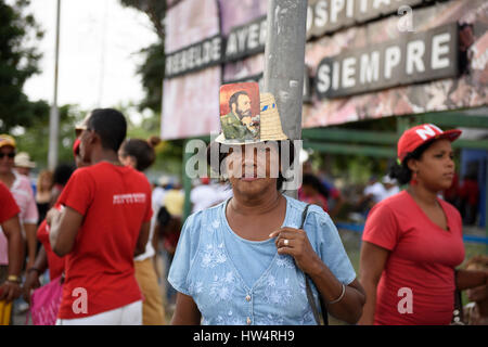 Cuban woman wearing a hat with Fidel Castro photograph attached during the May Day celebrations in Santiago De Cuba, Cuba. Stock Photo