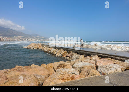 Photographer on pier. Code orange is given for tide and wind. Fuengirola, Malaga, Andalusia. Spain Stock Photo