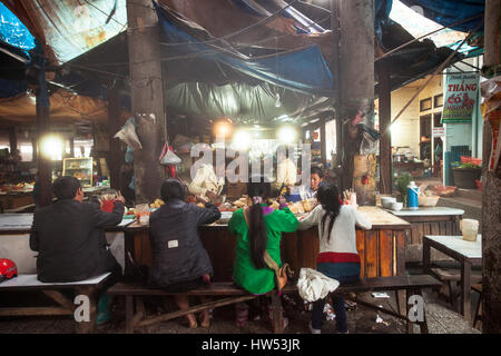 Sapa, Vietnam - May 06, 2014: Local people eating at the big table on the street market in Sapa, Vietnam. Stock Photo