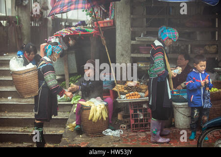 Sapa, Vietnam - May 6, 2014: Hmong women in traditional clothes are buying goods at the local market in Sapa village, Lao Cai, Northern Vietnam. Stock Photo
