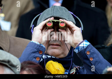 A racegoer watches the action through his binoculars during Gold Cup Day of the 2017 Cheltenham Festival at Cheltenham Racecourse. PRESS ASSOCIATION Photo. Picture date: Friday March 17, 2017. See PA story RACING Cheltenham. Photo credit should read: Ben Birchall/PA Wire. Stock Photo