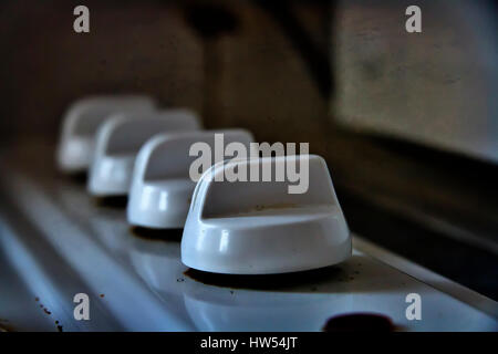 Switch dials on an old and worn electric cooker hob Stock Photo