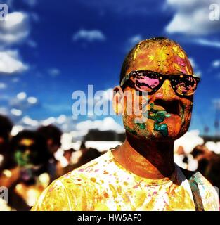 Portrait of a man covered in colored paint at Holi festival, Battersea Power Station, London, England, UK Stock Photo