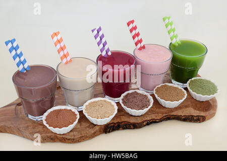 Healthy diet supplement drinks with corresponding  powders of chocolate whey, maca root, acai berry,  pomegranate fruit and wheatgrass. Also used by b Stock Photo