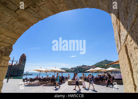 Arch framed view over the Collioure Town waterfront cafes towards the belltower of Notre Dame des Anges, Collioure, Côte Vermeille, France Stock Photo