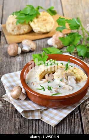 Mushroom sauce with bread dumplings served in a ceramic bowl on a wooden table Stock Photo