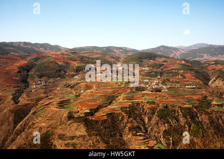 Panoramic view of chinese agriculture village landscape surrounded by red colored mountains and hills in the morning. Stock Photo