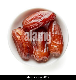 Bowl of pitted dates isolated on white background, top view