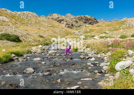 Italy, Valle d'Aosta, La Thuile, hikers crossing a small stream in the Valley of Beautiful Comba Stock Photo