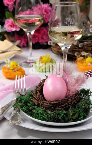 Decorative serving of the table for Easter. A painted egg in a nest on a plate with moss Stock Photo