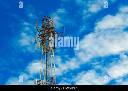 Phone tower on a background of blue sky and clouds. Stock Photo