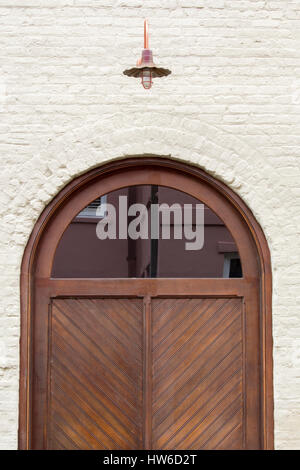 Round top wooden door, glass half circle with reflection and antique lamp Stock Photo