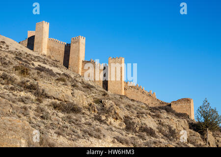 Hill with old city wall intersected with towers under a blue sky. Albarracin, Teruel, Spain. Stock Photo