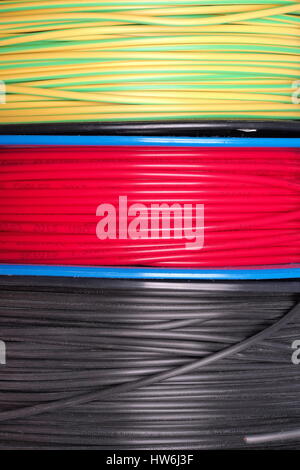 Melbourne, Australia, 2015, November 27: Three small reels with insulated yellow, red and black installation wire Stock Photo