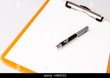 pen or pencil on empty paper in brown clipboard on white - business concept Stock Photo
