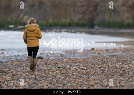 A woman walking along the beach at Saltburn-by-the-Sea (Saltburn) Stock Photo
