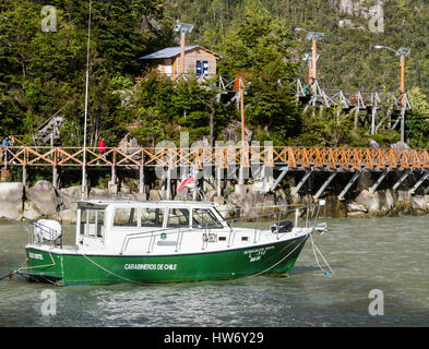 Police boat (carabineros de Chile) anchors in bay of Caleta Tortel, near wooden boardwalk, Caleta Tortel, Aysen region, Patagonia, Chile Stock Photo