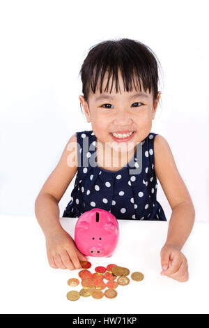 Asian Little Chinese Girl Saving Money in a Piggy Bank isloated on White Background Stock Photo