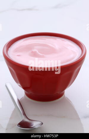 Delicious french custard-style yogurt with all the fruit mixed inside during the process. On vintage Italian carrara marble retro styling. Stock Photo