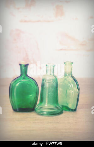 Selection of coloured glass bottles on a rustic background Stock Photo