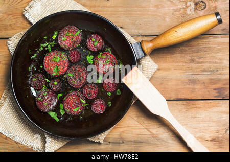 Fried beet slices on a cast-iron frying pan. Top view. Flat lay Stock Photo