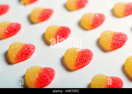 Sweet bright candies in the form of hearts on a white background. Shallow DOF, soft focus. Stock Photo